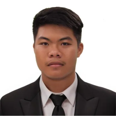 Young man in black suit and tie against white background